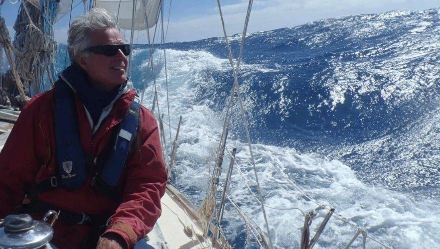 Why Every Sailor Should Learn Sailboat Rigging Basics. Sailor navigating offshore waves with visible sailboat rigging — sailboat rigging guide for beginners learning how to rig a sailboat.