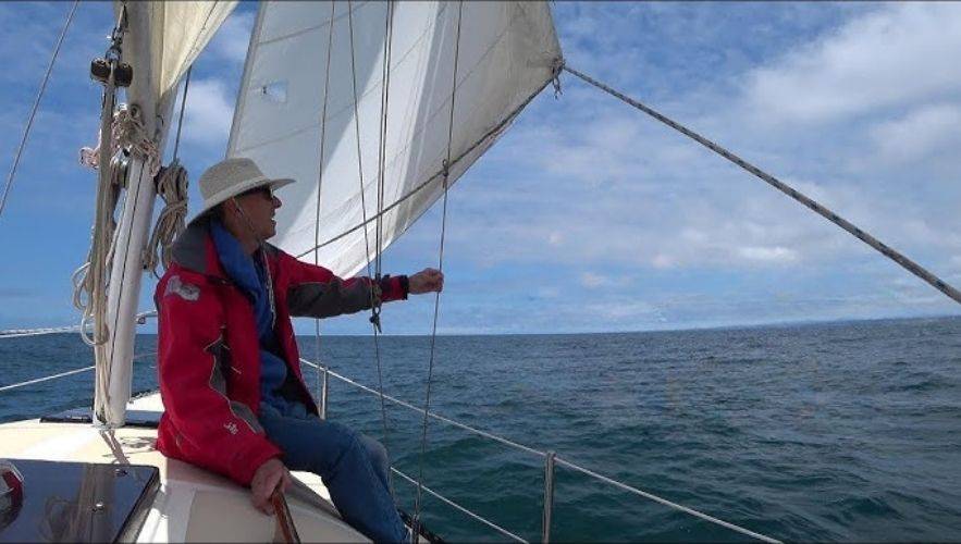 Why Every Sailor Should Learn Sailboat Rigging Basics. Sailor navigating offshore waves with active sailboat rigging — sailboat rigging guide for beginners learning how to rig a sailboat.
