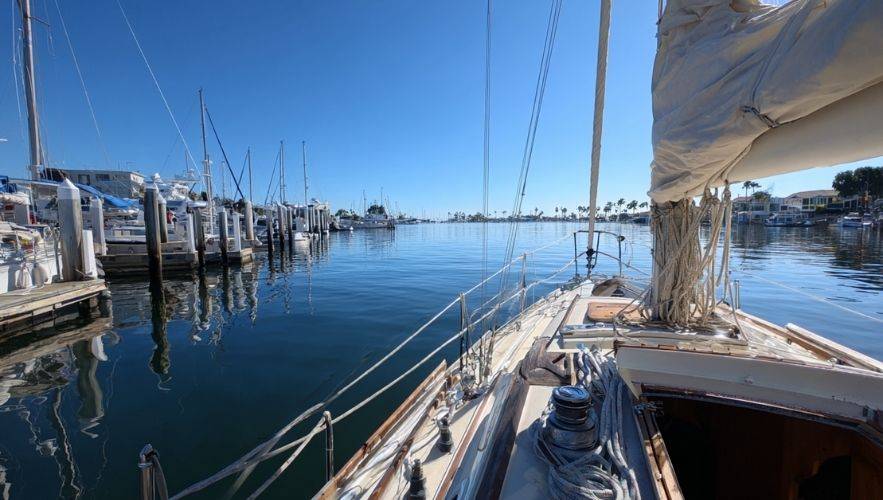 Sailboat positioned for fundamental docking and mooring techniques in a marina, demonstrating proper sailboat docking and mooring techniques.