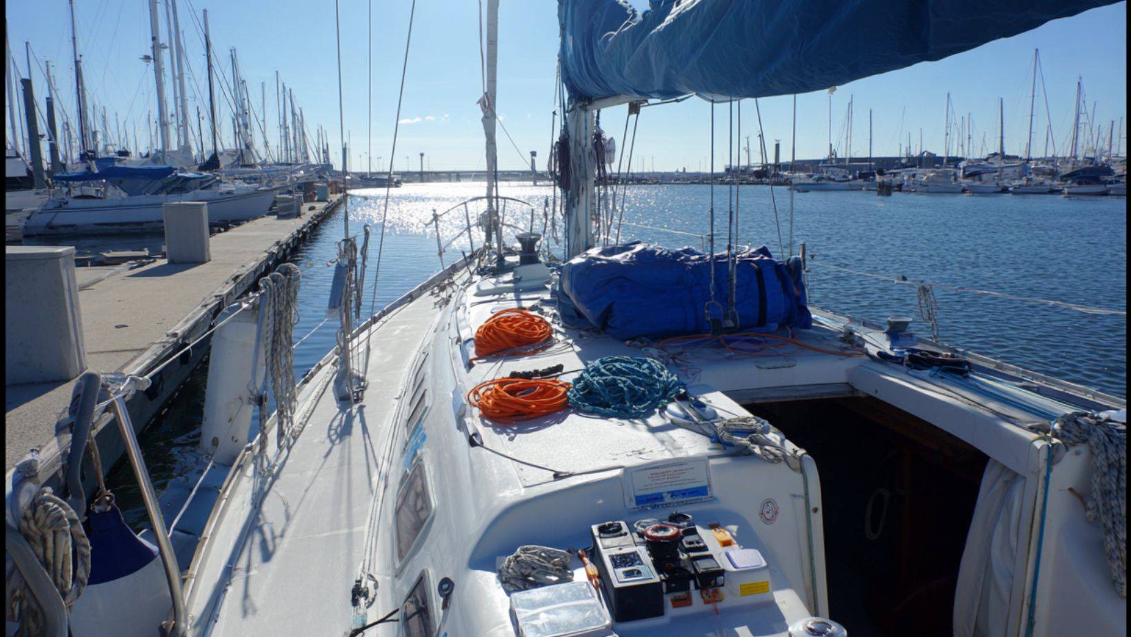 Sailboat maintenance seasonal maintenance tips showing deck inspection and line organization at the marina